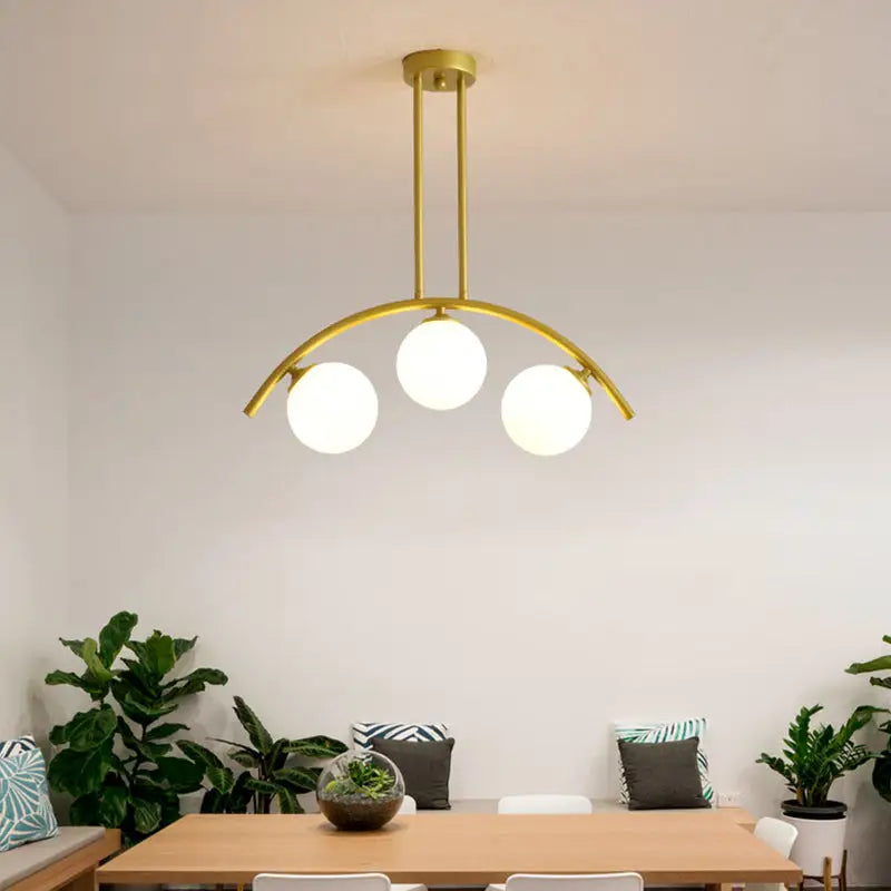 Modern gold metal ceiling light with three frosted glass bulbs in an arched design for dining room use