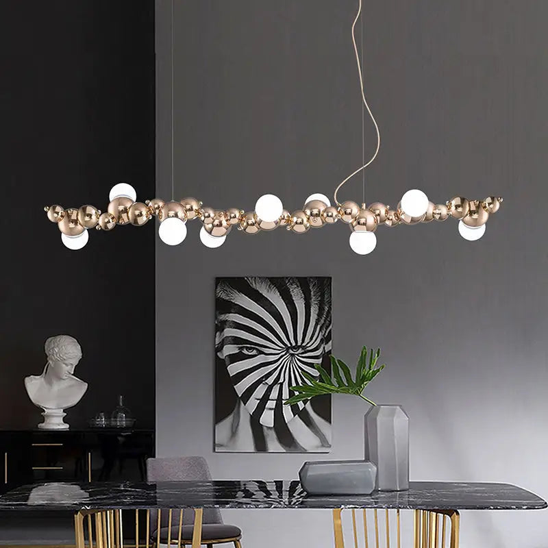 Modern gold metal arched ceiling light with six bulbs featuring polished spheres and frosted glass globes for dining room