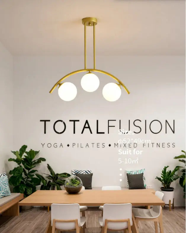 Modern gold metal arched ceiling light with three spherical white glass bulbs for dining room use