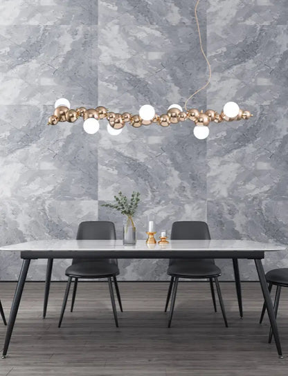 Modern gold metal arched ceiling light with 6 bulbs featuring gold-toned spheres and white globes for dining room use