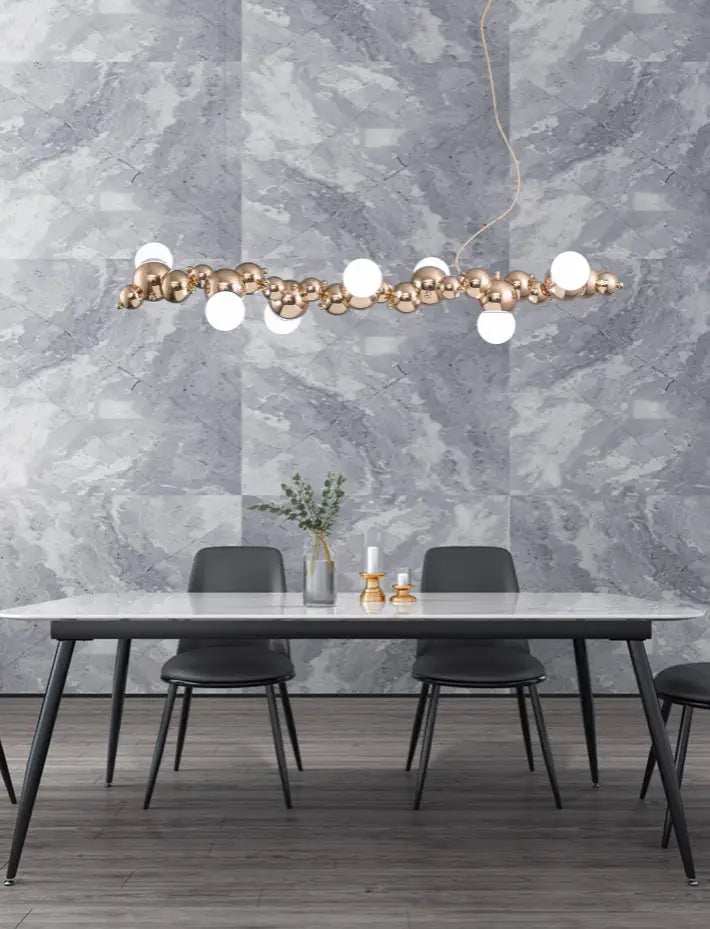 Modern gold metal arched ceiling light with 6 bulbs featuring gold-toned spheres and white globes for dining room use