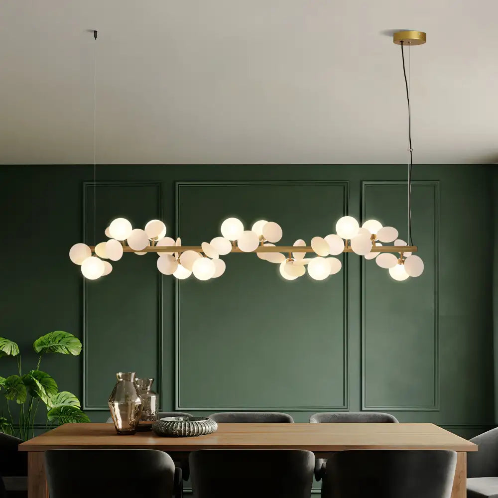 Modern gold metal branching pendant light with brass finish and spherical frosted glass bulbs for dining room decorbites gold metal