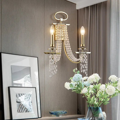 Modern gold metal candle wall sconce with two crystal candle bulbs and cascading glass beads for living room light