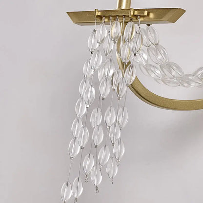 Modern gold metal candle wall sconce with crystals featuring a clear faceted glass chandelier and gold-toned metal frame