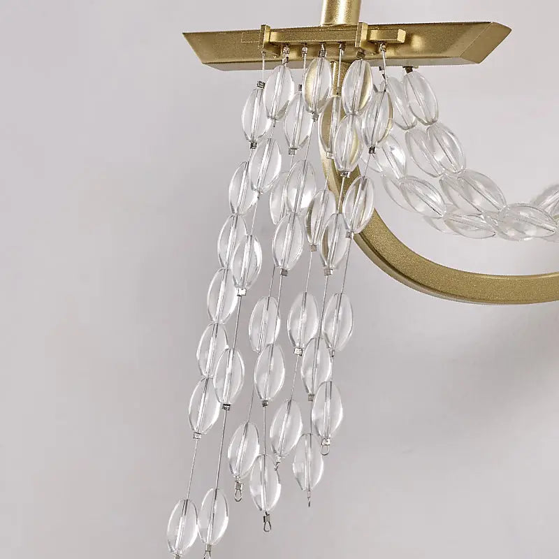Modern gold metal candle wall sconce with crystals featuring a clear faceted glass chandelier and gold-toned metal frame