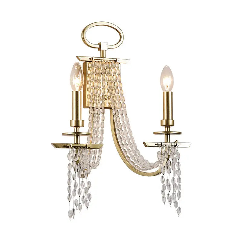 Modern gold metal candle wall sconce with two candle-style lights and cascading clear crystal beads for living room lighting