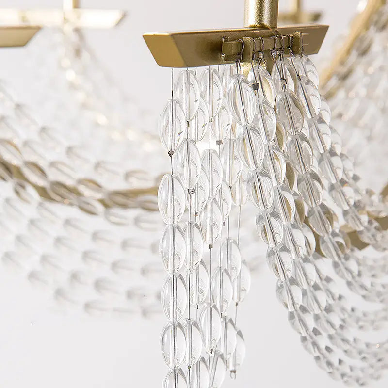 Modern gold metal candle wall sconce with clear faceted crystal chandelier and gold-toned metal frame for living room light