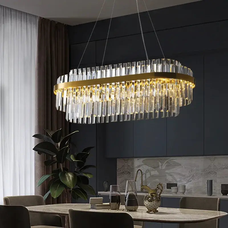 Modern gold metal crystal pendant light with oval frame and cascading rods emitting warm dimmable light for dining room decorbites gold metal
