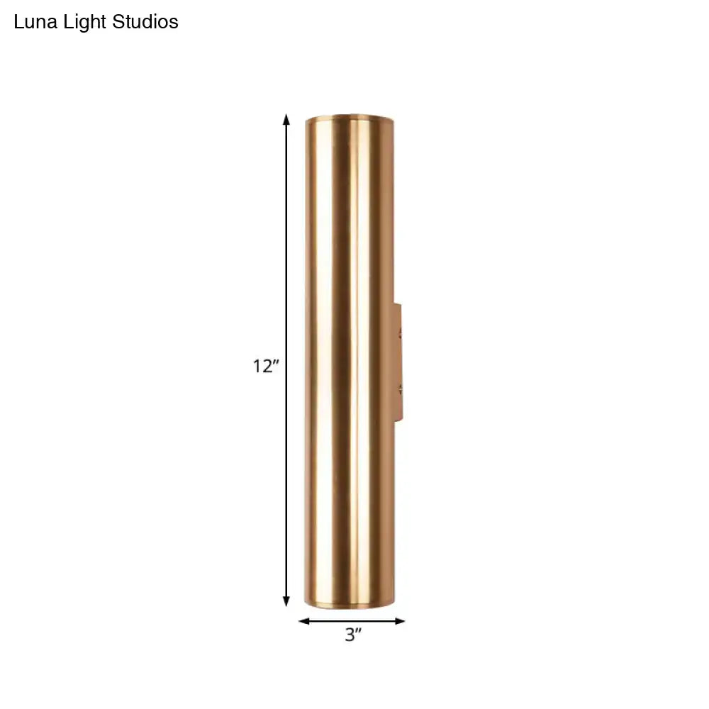 A sleek 12 inch tall brass cylindrical metal fixture wall lamp with polished finish for modern corridor lighting