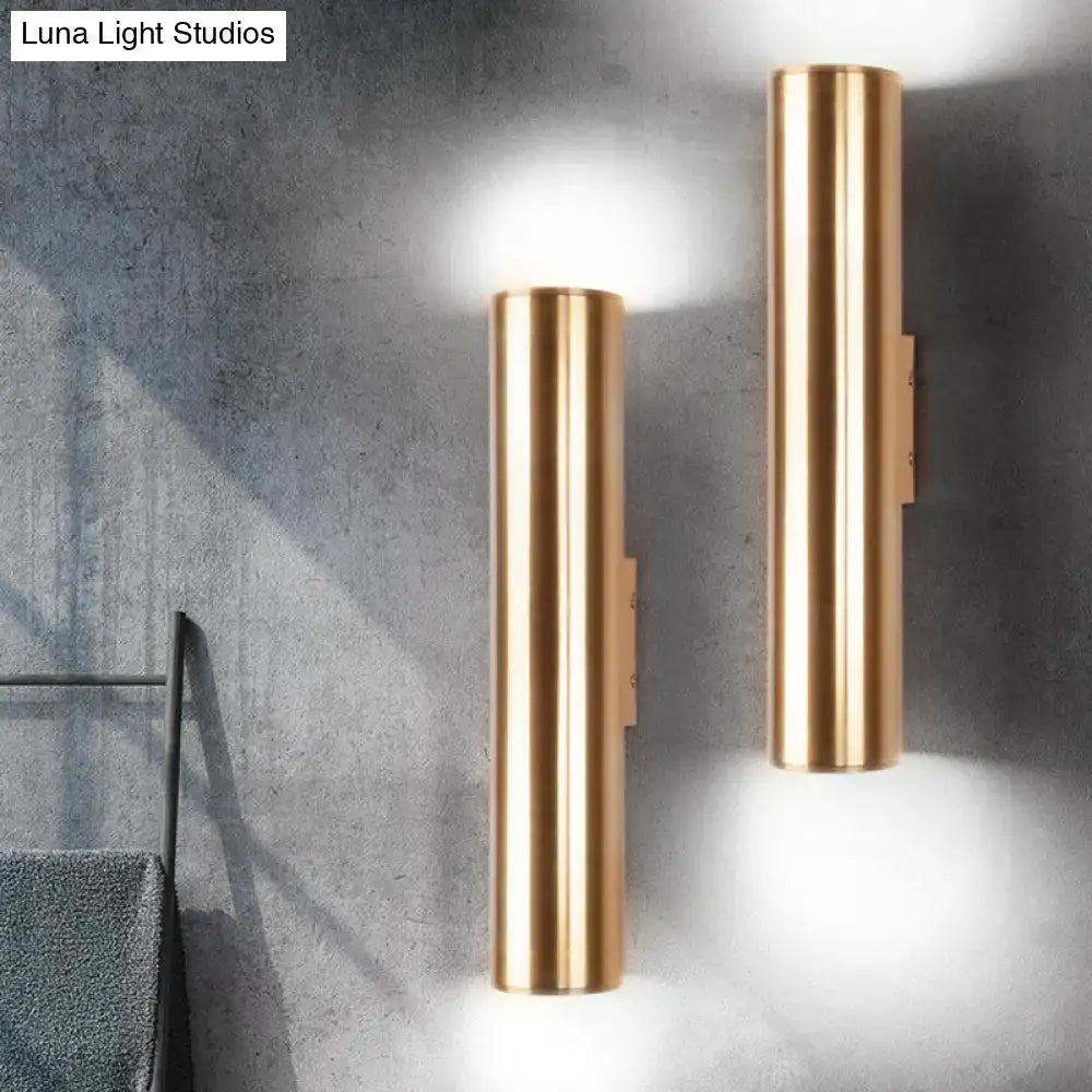 Two sleek cylindrical gold-toned metal fixture wall lamps with brushed finish for modern corridor lighting