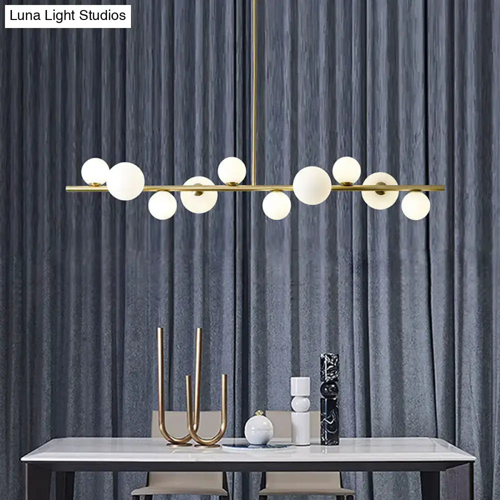 Modern gold metal glass globe chandelier with frosted glass bulbs and adjustable chain cord length for dining table lighting