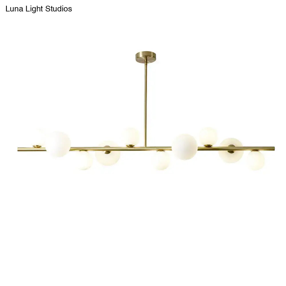 Modern gold metal chandelier with frosted glass globe bulbs and adjustable chain cord length for dining table lighting