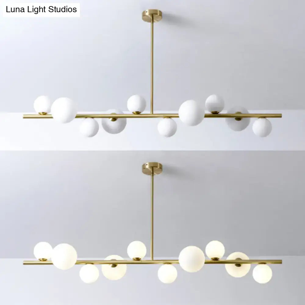 Modern gold metal glass globe chandelier with chain cord length features white spherical globes for dining table use