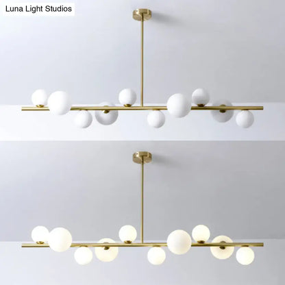 Modern gold metal glass globe chandelier with chain cord length features white spherical globes for dining table use