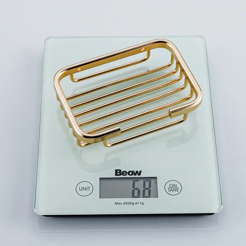 Modern gold metal glass soap dish with sleek horizontal bars and rounded edges for bathroom wall mounting