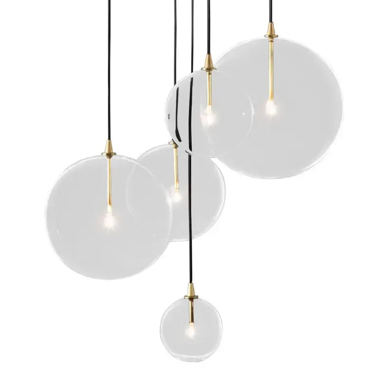 Modern gold metal globe pendant light with spherical glass, brass accents, and black cords for dining room decorbites pendant light