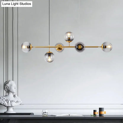 Modern gold metal island pendant with brass bar and clear smoky glass globe bulbs for dining room lighting