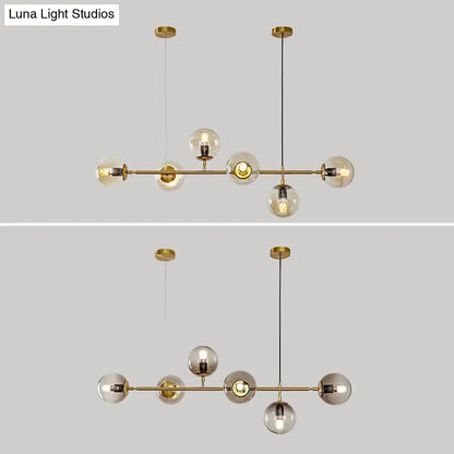 Modern gold metal island pendant with brass finish and blue glass spheres featuring clear and smoked globe shades