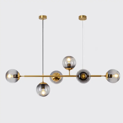 Modern gold metal island pendant with six smoked glass globes and central bar for dining room lighting