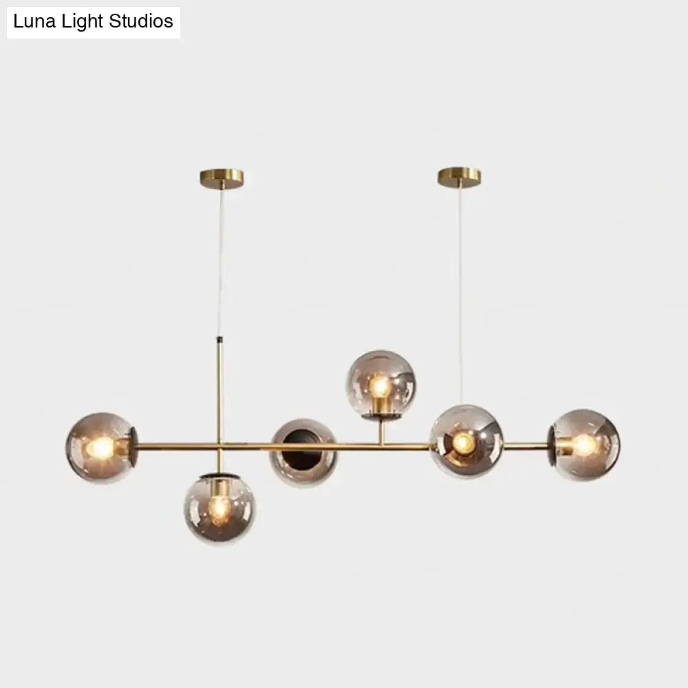Modern gold metal island pendant with brass chandelier featuring five smoked glass globe bulbs for dining room