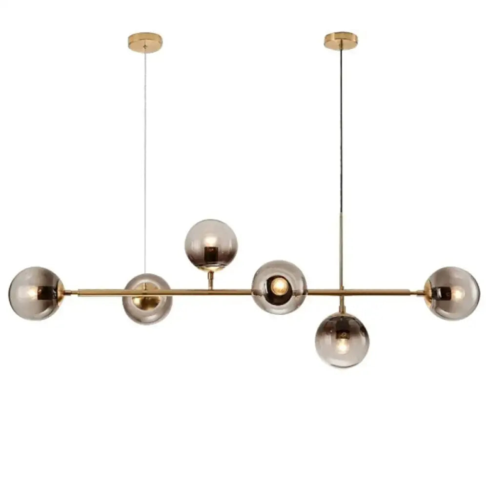 Modern gold metal pendant lighting featuring brass and smoked glass spherical bulbs for dining room use