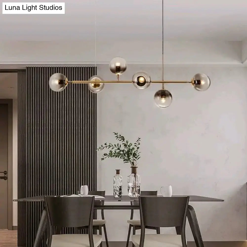 Modern gold metal pendant lighting with six spherical smoke glass globes for dining room illumination