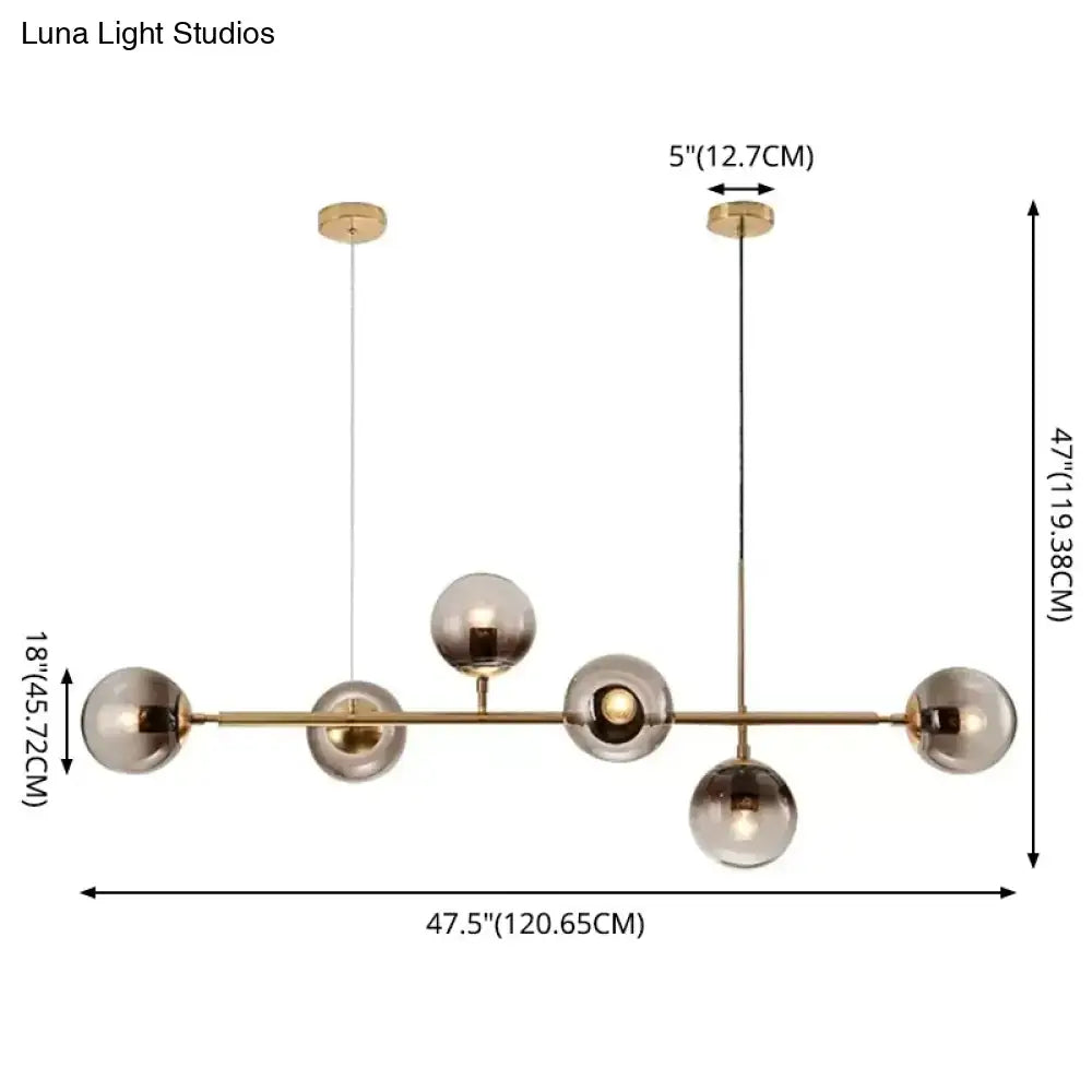 Modern gold metal pendant lighting featuring brass and smoked glass globes in a sleek minimalist design for dining rooms