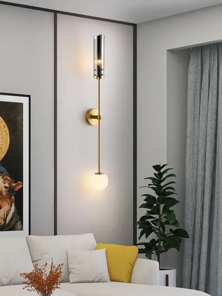 Modern gold metal wall sconce with cylindrical glass shade and frosted globe bulb for bedroom decorbites metal wall light