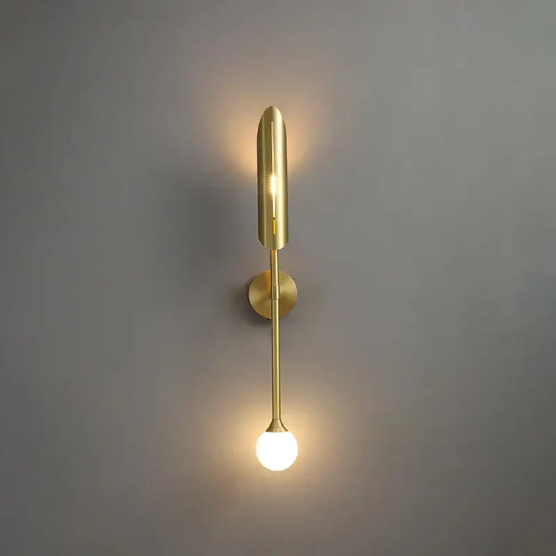 Modern gold metal wall light with sleek elongated design and frosted globe for bedroom decorbites gold metal sconce