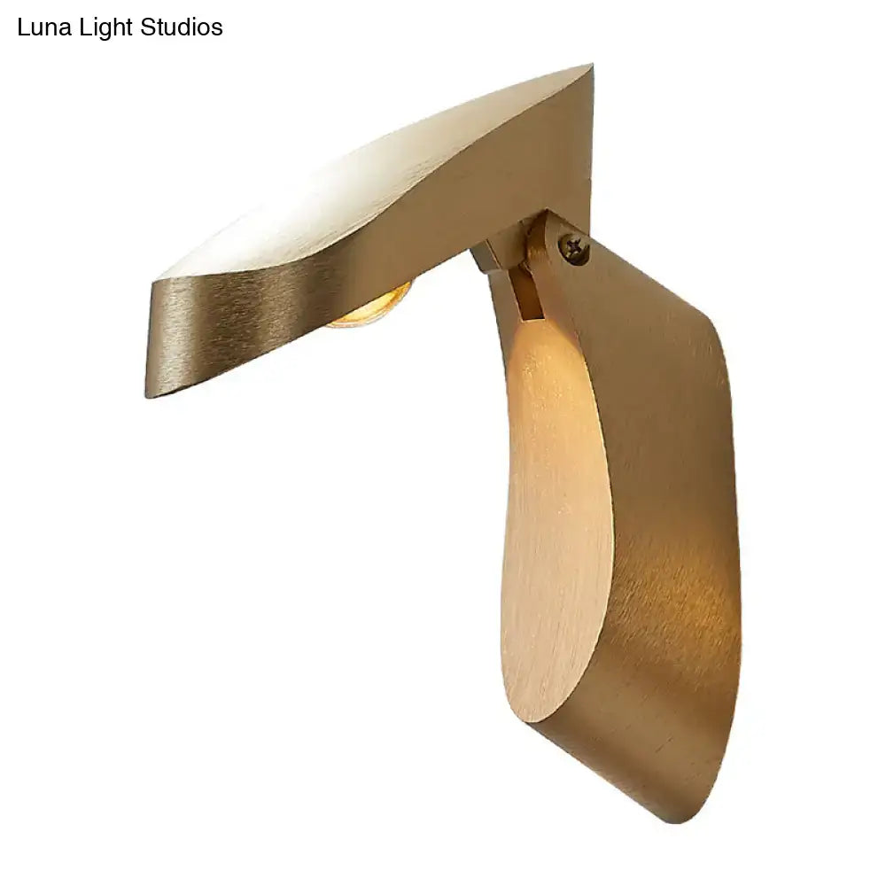 Modern gold metal wall light with brass sculptural design providing warm ambient lighting for bedroom use