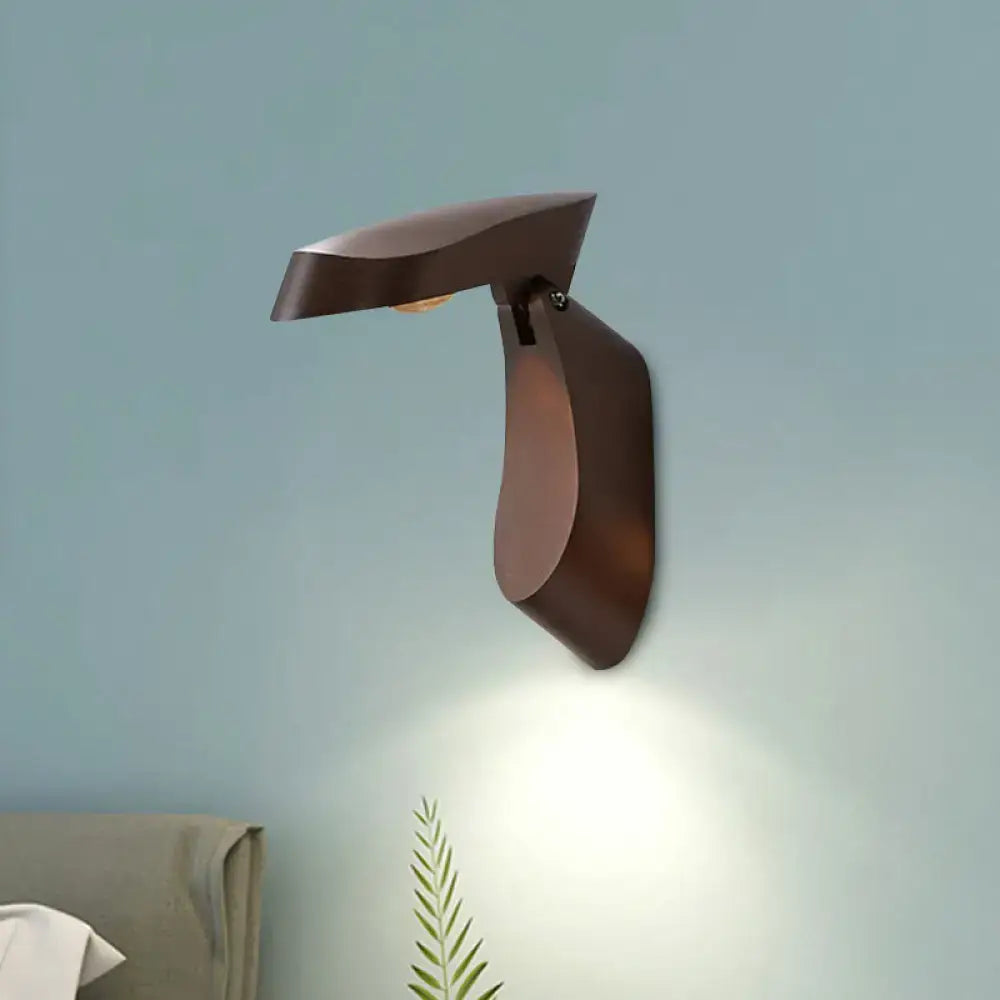 Modern gold metal wall light with bronze finish and sleek sculptural design casting warm glow for bedroom use