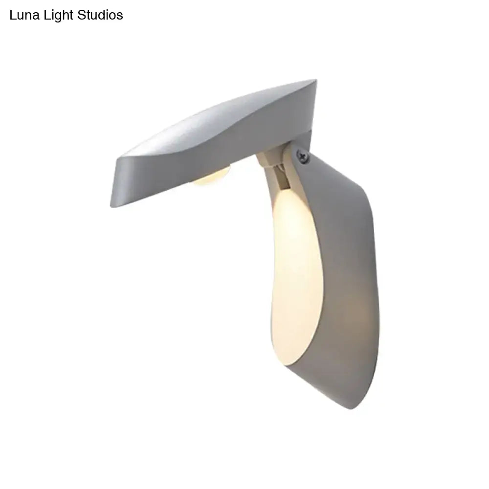 Modern gray metal wall light with sleek angular design and warm ambient lighting for bedside use