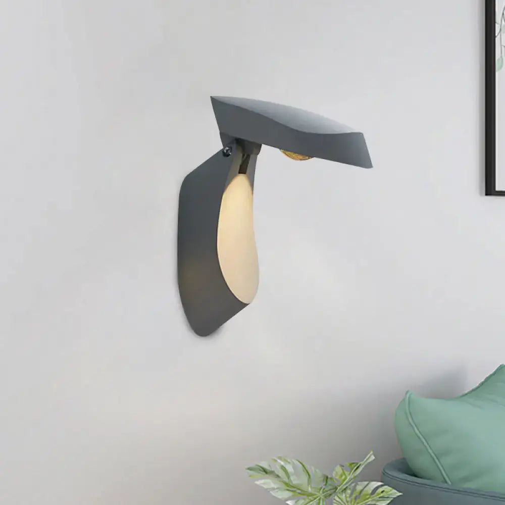 Modern matte gray metal wall light with sleek angular design and warm light diffuser for bedroom use