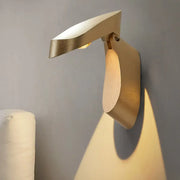 Modern gold metal wall light bedside fixture with sleek angular design casting warm light for bedroom use