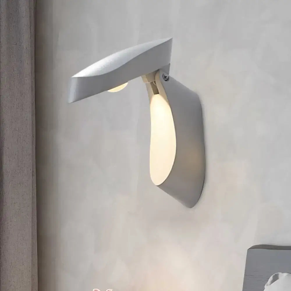 Modern gold metal wall light with sleek angular white wall-mounted reading lamp and adjustable light beam for bedroom