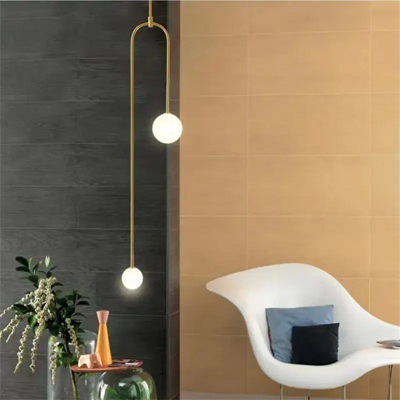 Gold minimalist iron chandelier with two spherical glass bulbs suspended by a curved arm for dining room decorbites black