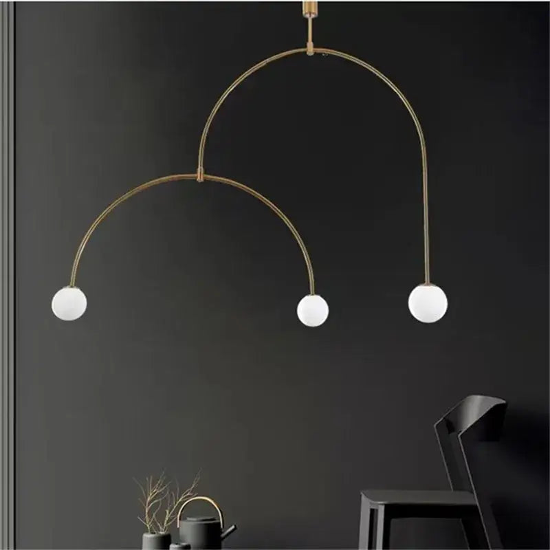 Modern gold minimalist iron chandelier featuring a brass arched pendant light with three white glass bulbs for dining room decorbites black