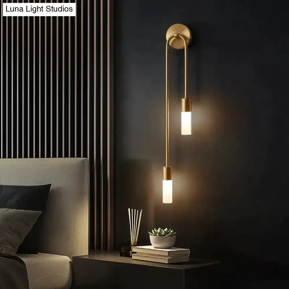 Modern gold minimalist led wall lamp with two vertical cylindrical bulbs and a sleek curved arm for bedroom use