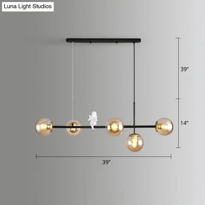 Black metal modo island pendant light with five amber glass globes and a milk white angel figurine for restaurants