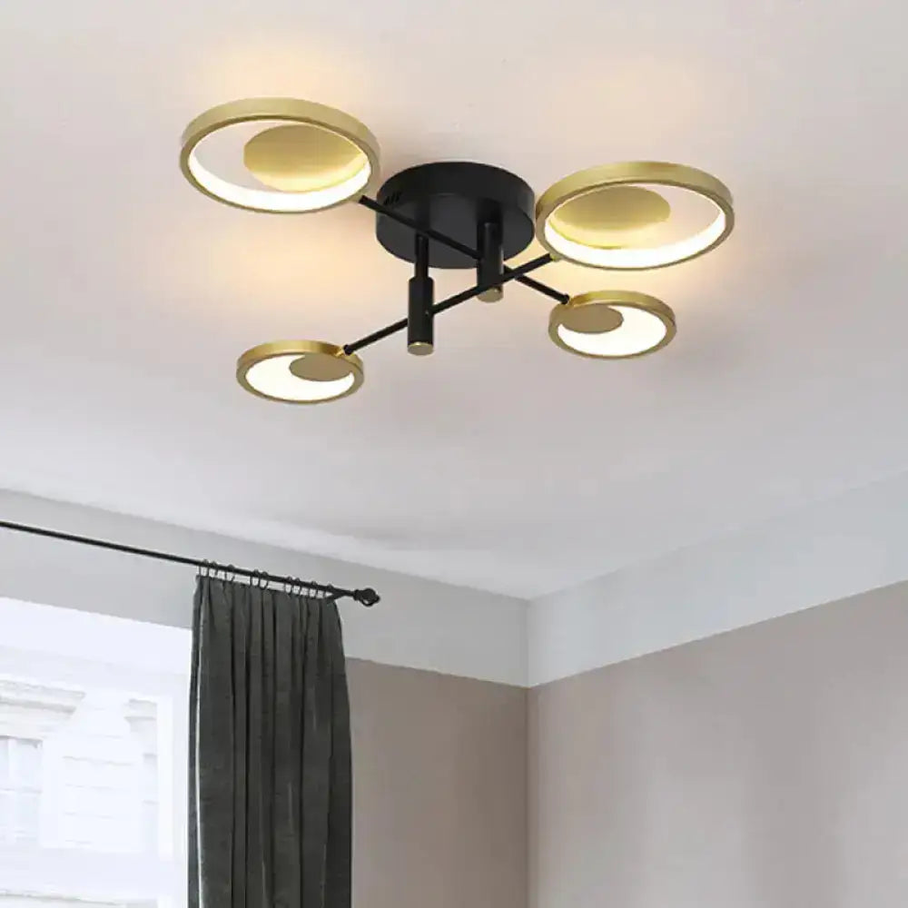 Modern gold molecule ceiling mount chandelier with four circular gold-toned rings and warm white illumination