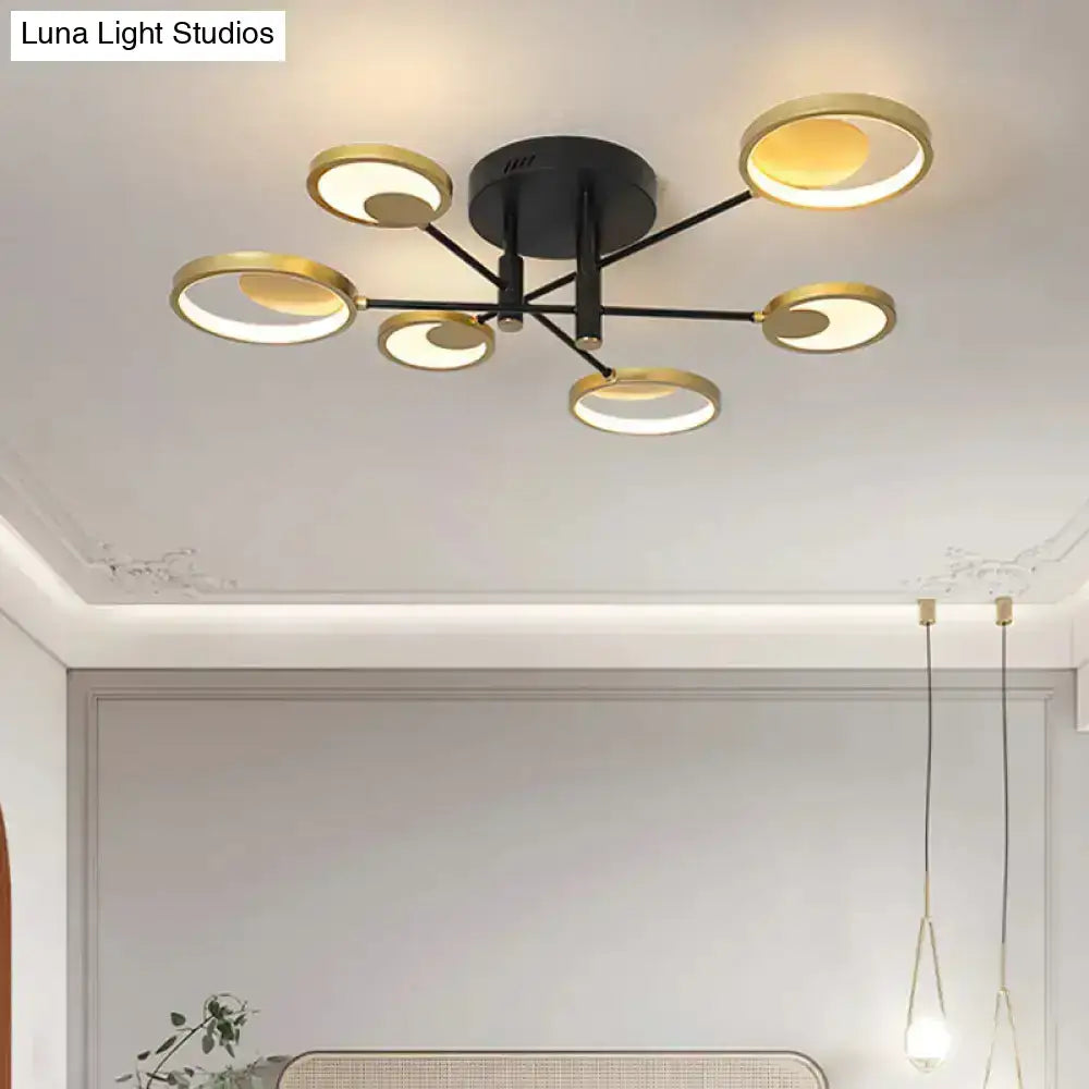 Modern gold molecule ceiling mount chandelier with black base and six illuminated gold-toned circular rings