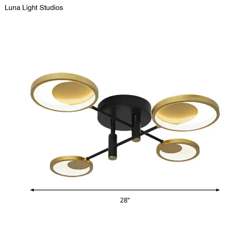 Modern gold molecule ceiling mount chandelier with four gold circular shades and illuminated inner circles for living room use