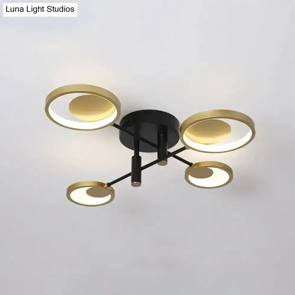 Modern gold molecule ceiling mount chandelier with black base and four gold circular rings housing led panels