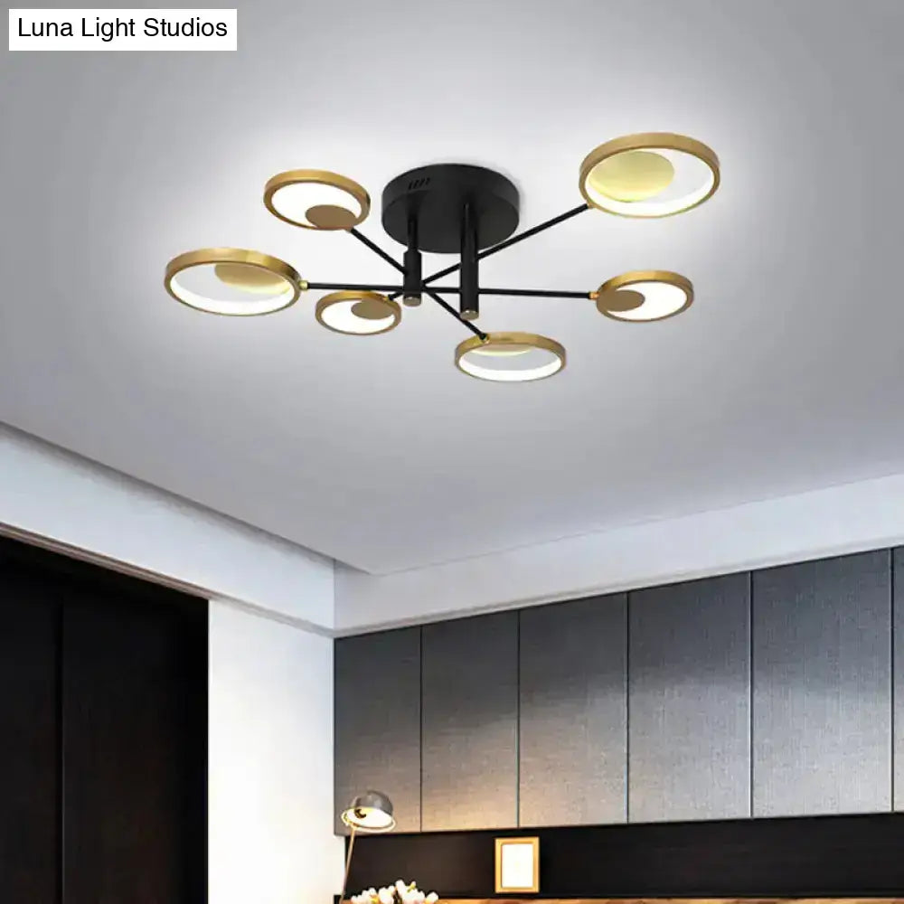 Modern gold molecule ceiling mount chandelier with six circular gold-toned rings and warm ambient lighting