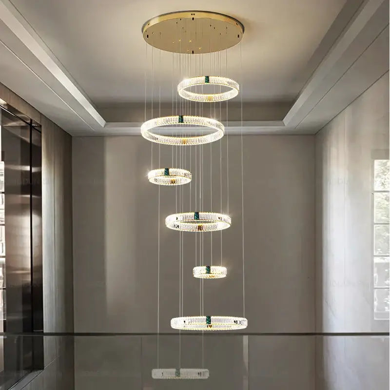 Modern gold multi tier duplex crystal chandelier with five clear crystal rings and green accents for living room use