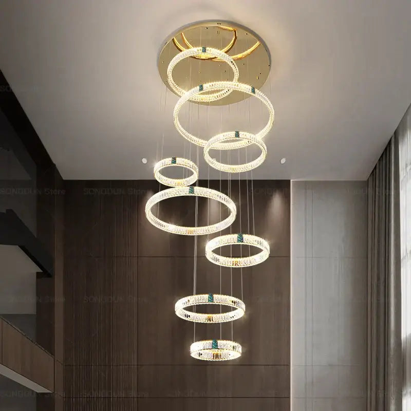 Modern gold multi tier duplex crystal chandelier with cascading crystal rings and green gemstones for living room