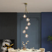 A modern brass decorbites gold nordic pendant light with five glass bulbs cascading for dining room chandelier decor