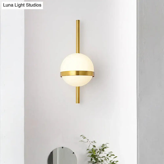 Modern gold opal glass orb wall sconce with a frosted opal glass orb and minimalist metallic gold accents for living room lighting