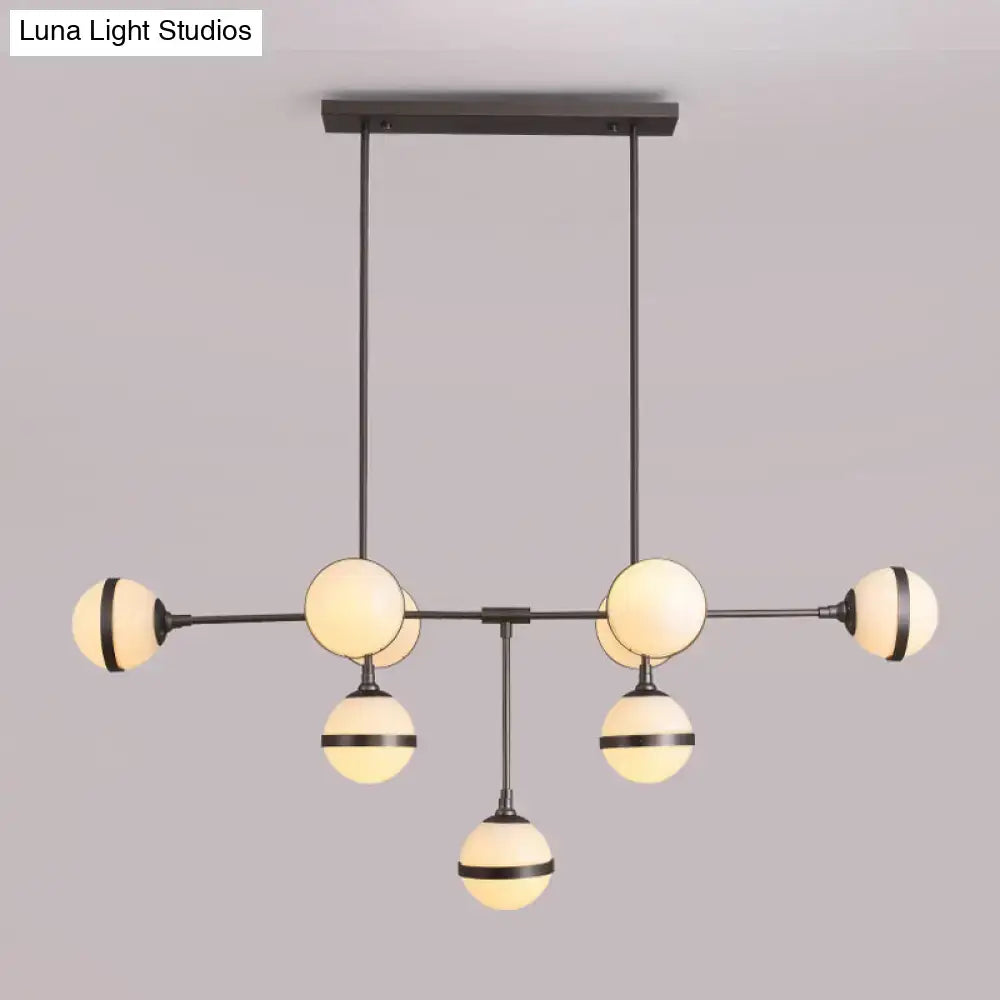 Modern black metal orb chandelier with six warm glass globes and silver gold bulb base perfect for restaurant lighting