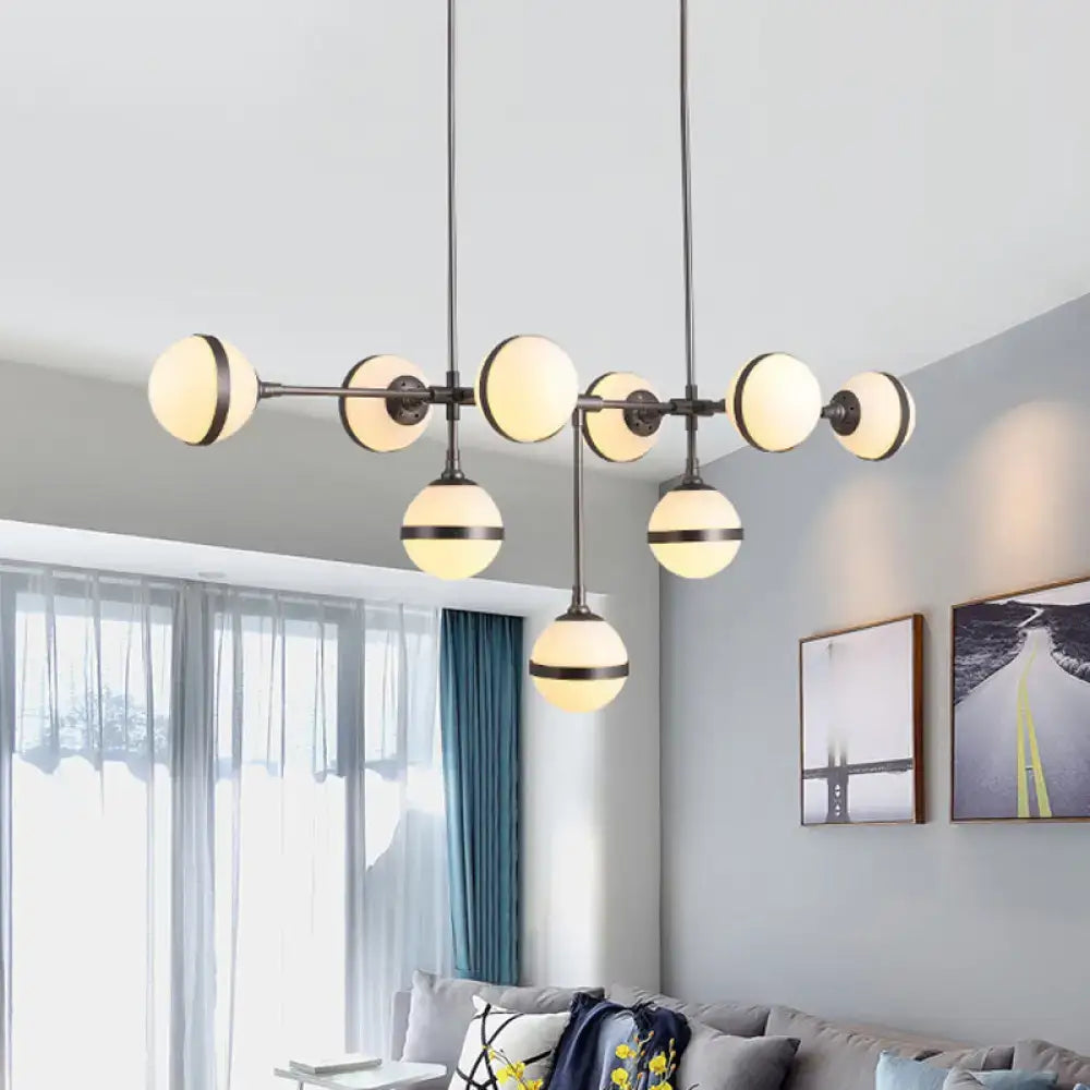 Modern black metal orb chandelier with nine frosted glass shades and silver gold bulb base finish for restaurant lighting